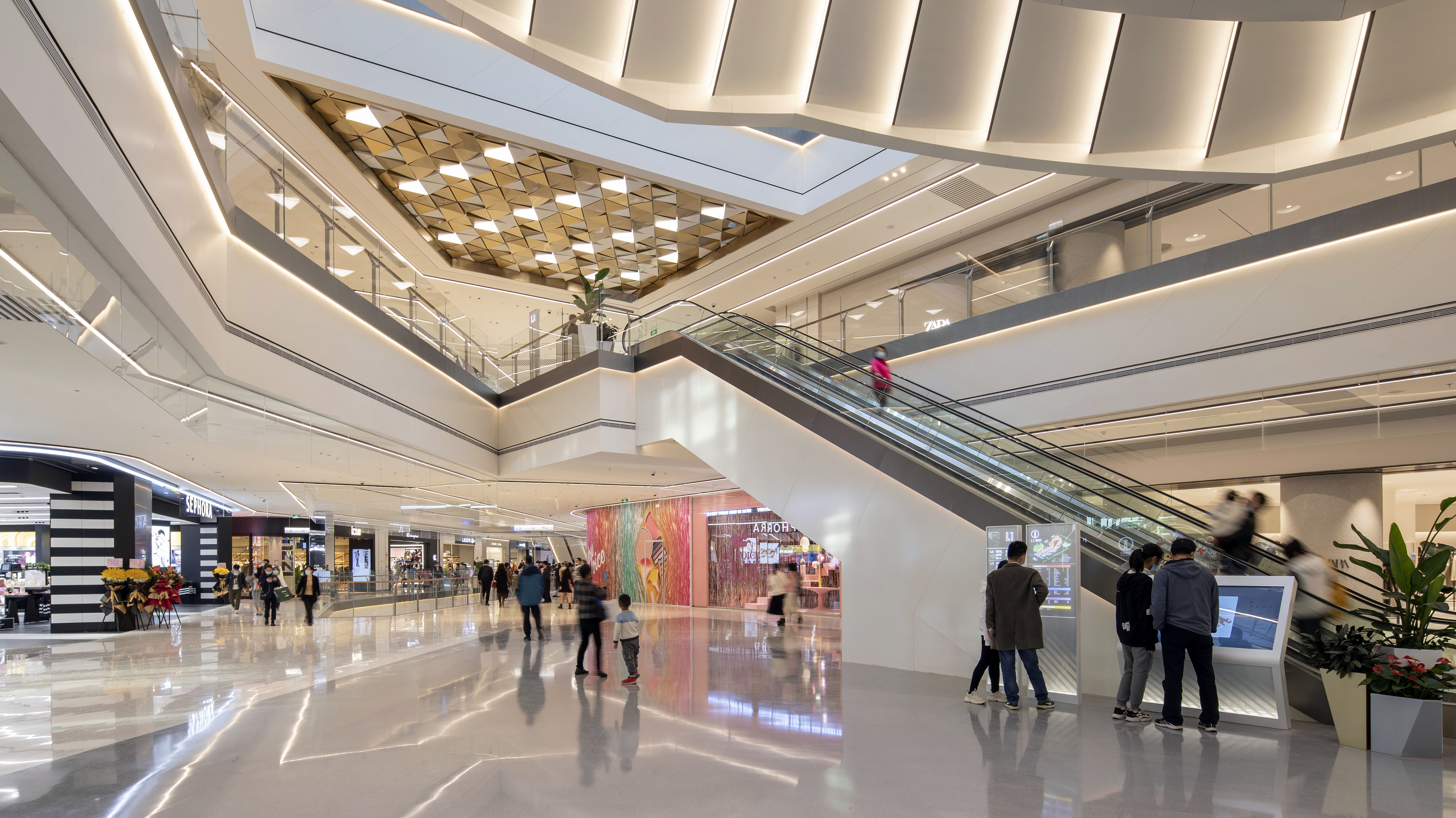 A bright, contemporary designed mall with numerous visitors.