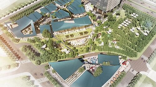 Bird's eye view of a modern shopping area with striking roofs in the midst of green surroundings.