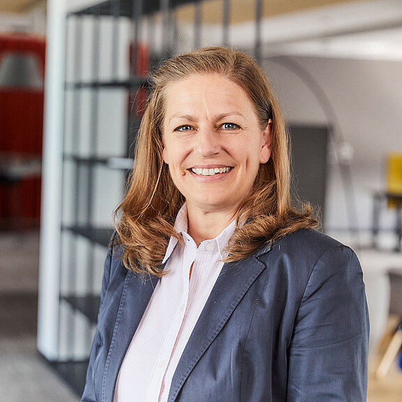 Portrait von Birgit Gever, die freundlich in die Kamera lächelt.