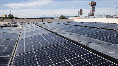 Eine Photovoltaikanlage, die aus mehreren Solarzellen besteht, ist auf einem Dach angebracht.