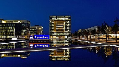 Hell erleuchtete Gebäude und Firmenzeichen von ThyssenKrupp 