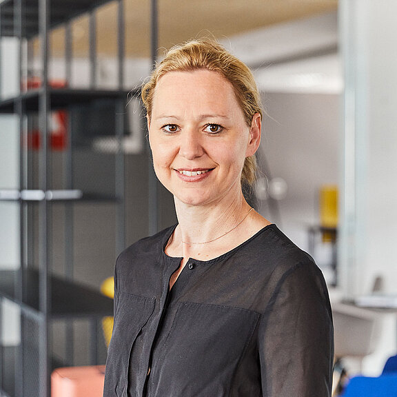 Portrait von Bernadette Atzinger, die freundlich in die Kamera lächelt.
