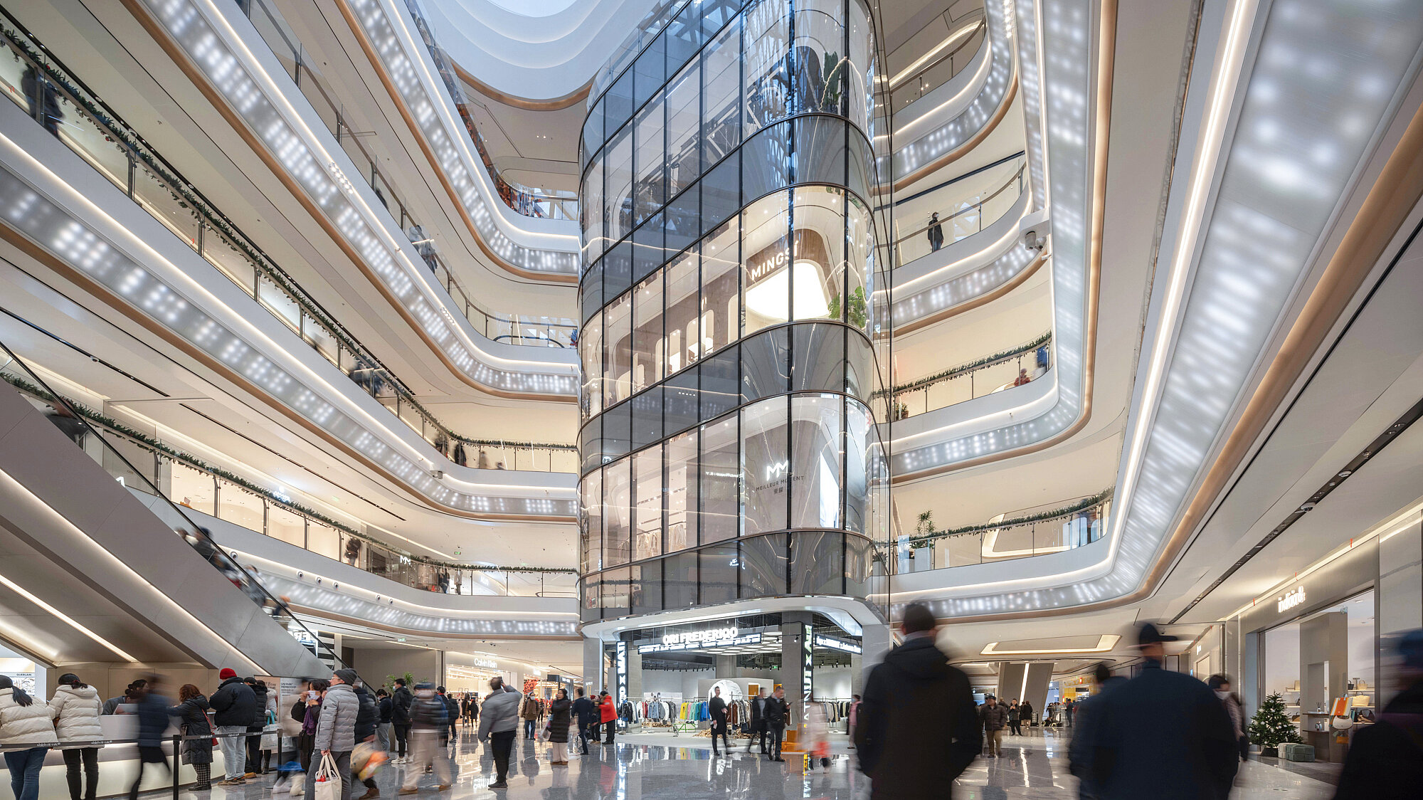 A bright, contemporary designed mall with numerous visitors.