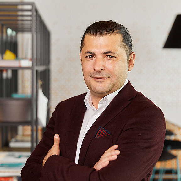 Portrait von Burak Dalgin, der freundlich in die Kamera lächelt.