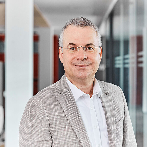 Portrait von Tamas Turi, der freundlich in die Kamera lächelt.