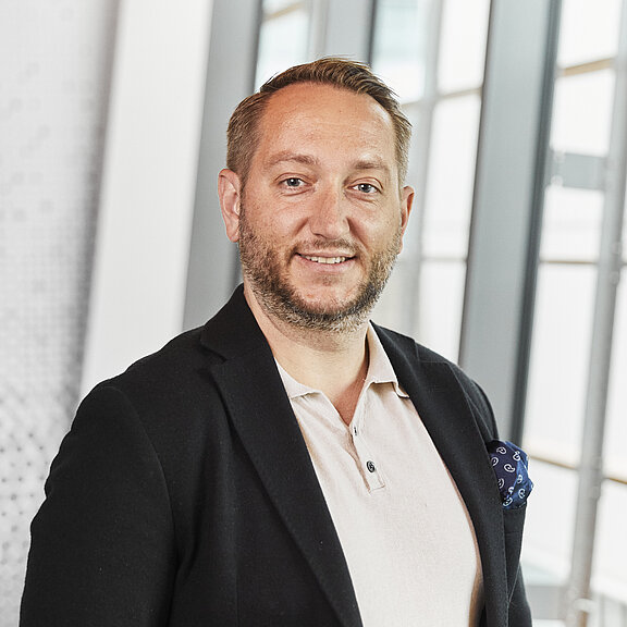 Portrait von Szymon Skwierczynski, der freundlich in die Kamera lächelt.