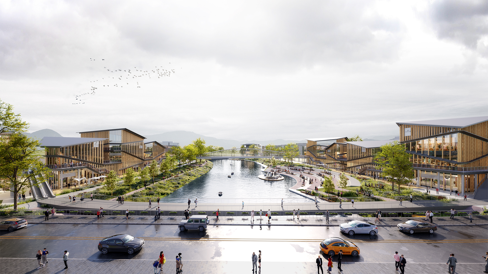 Der Blick fällt zunächst auf eine Straße im Vordergrund, die in eine Wasseranlage im Zentrum des Bildes mündet – eingerahmt von zwei modernen Gebäuden zu beiden Seiten.