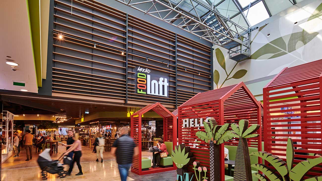 Das Innere eines Shopping-Centers mit Blick auf einen Gastronomiebereich und roter und grüner Dekoration