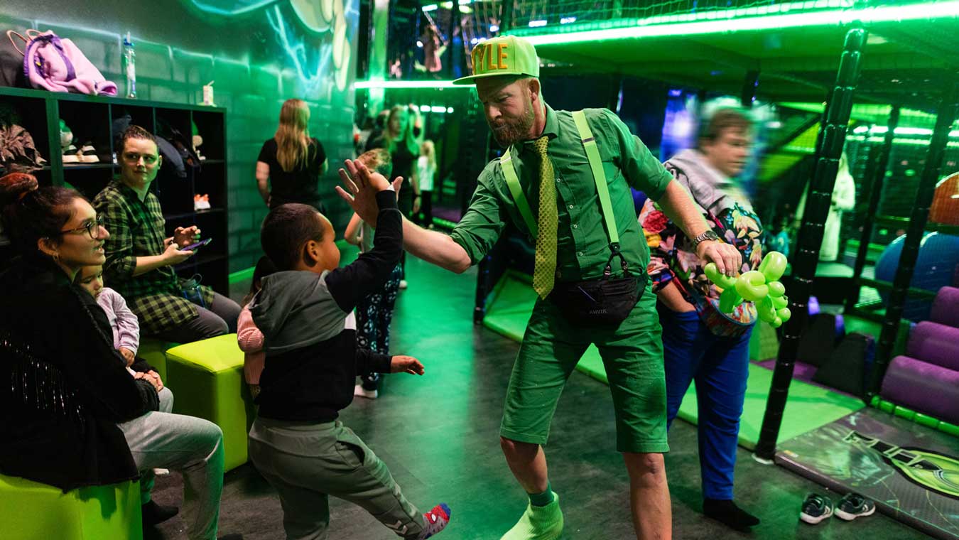 Es sind Menschen im FlipOut zu sehen, ein Kind gibt einem Erwachsenen einen High-Five.